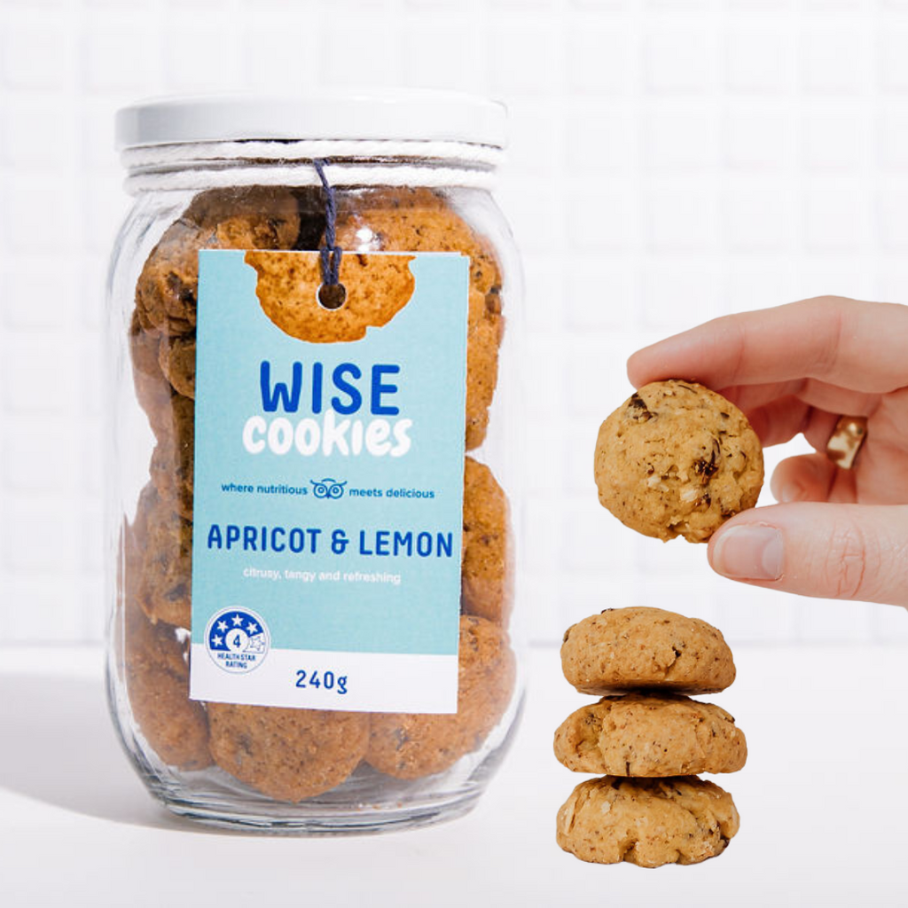 Wisefoods | 240g Glass Gift jar of 4.0 Health Star rated, allergy-friendly, plant based Apricot & Lemon Wise Cookies with a stack of cookies on the side and a hand holding one cookie between thumb and forefinger