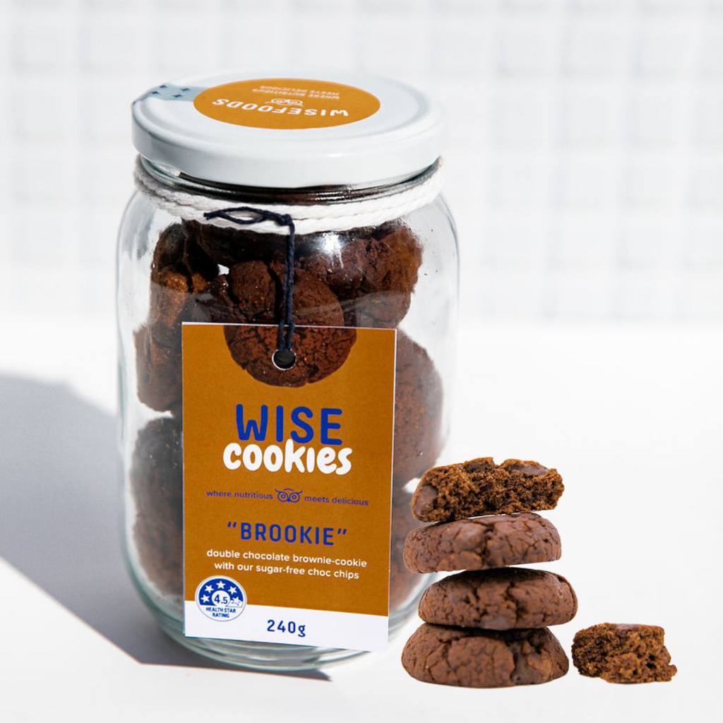 Wisefoods | 4.5 Health Star rated, allergy-friendly Double Choc "Brookie" Wise Cookies in a glass jar with a stack of loose cookies in the foreground